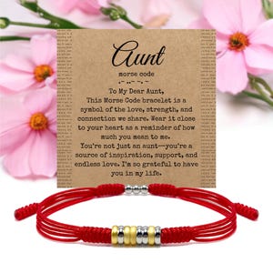 Könnte beinhalten: Rotes Armband mit goldenen und silbernen Perlen, kombiniert mit einer Karte. Die Karte zeigt das Wort "Aunt" in Schreibschrift, Morsecode und eine Botschaft über Liebe und Verbundenheit.