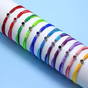 May include: A set of 10 colorful bracelets with silver beads and colorful gemstones. The bracelets are arranged in a rainbow pattern, with red at the top and yellow at the bottom.