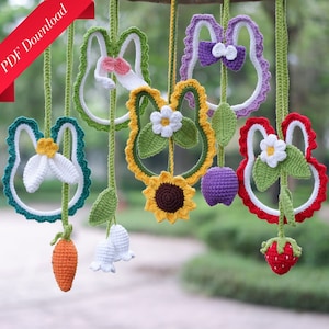 May include: A set of seven crocheted hanging ornaments featuring a variety of designs, including bunnies, flowers, and fruit. The ornaments are made in a variety of colors, including green, red, yellow, purple, and white.