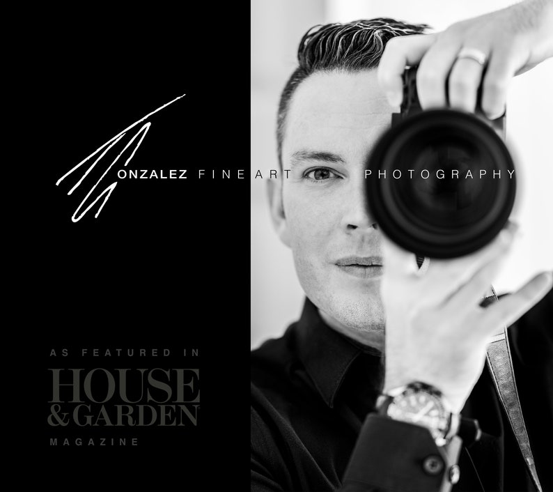 May include: Black and white portrait of a photographer holding a camera to their eye. The photographer is wearing a black shirt and a watch. The text "GONZALEZ FINE ART PHOTOGRAPHY" is visible in the image. The text "AS FEATURED IN HOUSE & GARDEN MAGAZINE" is also visible in the image.