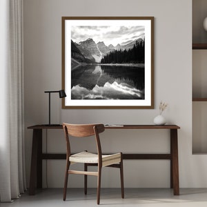 May include: A black and white photograph of a mountain lake with a reflection of the mountains in the water.