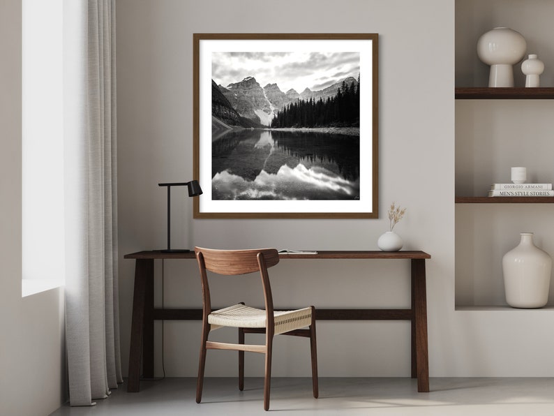 May include: A black and white photograph of a mountain lake with a reflection of the mountains in the water.