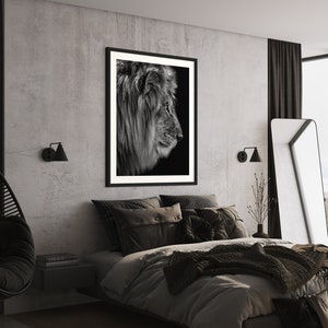 May include: A black and white photograph of a lion's profile hangs above a bed with black and grey bedding in a modern bedroom. The room features a concrete wall, black curtains, and a black hanging chair.
