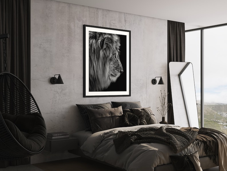 May include: A black and white photograph of a lion's profile hangs above a bed with black and grey bedding in a modern bedroom. The room features a concrete wall, black curtains, and a black hanging chair.