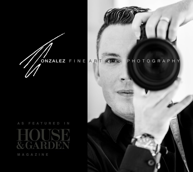 May include: Black and white portrait of a photographer holding a camera to their eye. The photographer is wearing a black shirt and a watch. The text "GONZALEZ FINE ART PHOTOGRAPHY" is visible in the image. The text "AS FEATURED IN HOUSE & GARDEN MAGAZINE" is also visible in the image.