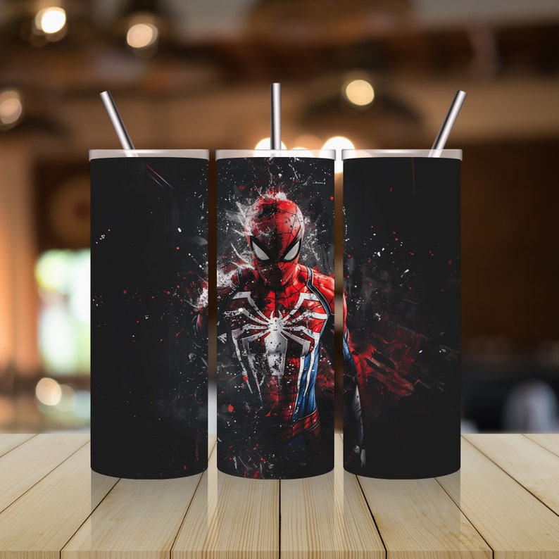 Puede incluir: Tres vasos de acero inoxidable con fondo negro y un gr&aacute;fico de Spiderman rojo y azul. El gr&aacute;fico est&aacute; estilizado con un salpic&oacute;n de pintura roja.