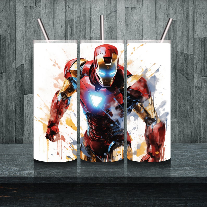 Op de afbeelding: Drie roestvrijstalen bekers met een witte achtergrond en een kleurrijk beeld van Iron Man in een superheldenpose. De afbeelding heeft een aquareleffect met spatten van gele, oranje en blauwe verf.