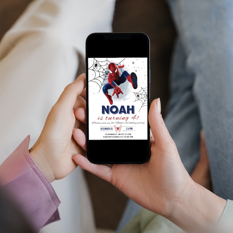 Peut inclure: Un smartphone affichant une invitation num&eacute;rique pour la f&ecirc;te d'anniversaire de Noah pour ses 4 ans. L'invitation pr&eacute;sente une image de dessin anim&eacute; de Spiderman en rouge et bleu, se balan&ccedil;ant sur une toile d'araign&eacute;e. Le texte indique "Noah a 4 ans !" et comprend la date et l'heure de la f&ecirc;te.