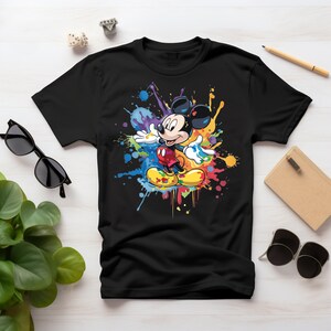May include: Black t-shirt with a colorful paint splatter design featuring Mickey Mouse in the center.