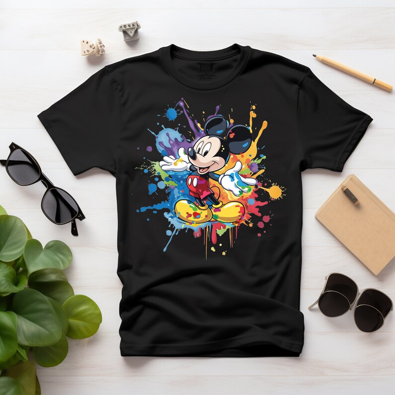May include: Black t-shirt with a colorful paint splatter design featuring Mickey Mouse in the center.
