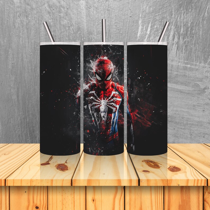 Puede incluir: Tres vasos de acero inoxidable con fondo negro y un gr&aacute;fico de Spider-Man con un traje rojo y azul. Los vasos tienen tapas y pajitas.