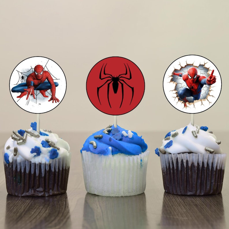 K&ouml;nnte beinhalten: Drei Cupcakes, verziert mit rotem, wei&szlig;em und blauem Frosting. Jeder Cupcake hat einen runden, essbaren Topper mit einem anderen Bild von Spiderman. Ein Topper zeigt Spiderman in einem Netz, ein anderer zeigt Spiderman in einem rot-schwarzen Anzug und der letzte Topper zeigt Spiderman in einem rot-blauen Anzug.