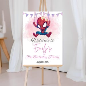 May include: A sign welcoming guests to Emily's 5th birthday party, with a cartoon Spider-Man swinging from a banner. The sign reads "Welcome to Emily's 5th Birthday Party" and the date "JULY 25TH, 2025". It is displayed on a wooden easel.