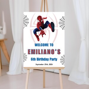 Op de afbeelding: Een wit bord op een houten ezel toont een afbeelding van Spider-Man. De tekst luidt "WELCOME TO EMILIANO'S 6th Birthday Party" en de datum "September 25, 2026". Spinnenwebben versieren de hoeken.