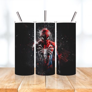 Puede incluir: Tres vasos de acero inoxidable con tapas y pajitas. Los vasos son negros con un gr&aacute;fico de Spiderman rojo y azul.