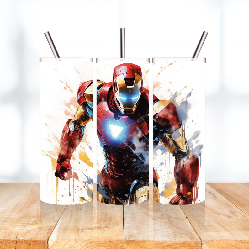 Op de afbeelding: Drie witte roestvrijstalen bekers met een kleurrijk aquarelontwerp van Iron Man, een superheld uit Marvel Comics. Het ontwerp bevat spatten in rood, geel en blauw.