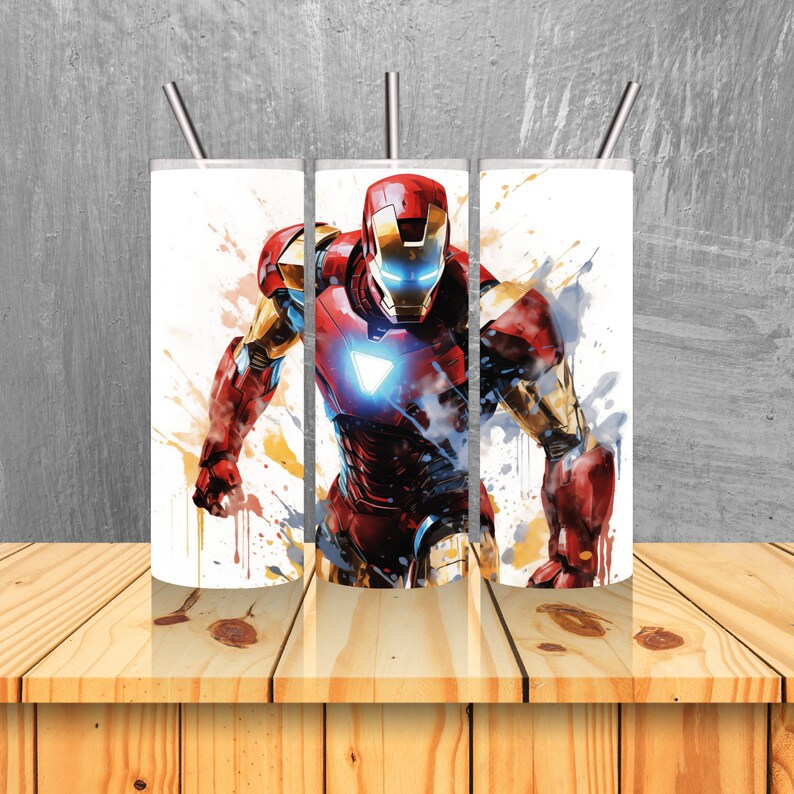 Op de afbeelding: Drie roestvrijstalen bekers met een kleurrijk abstract ontwerp met Iron Man, een superheld uit Marvel Comics. Het ontwerp bevat spatten van rode, gele en blauwe verf.