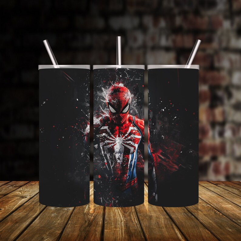 Puede incluir: Tres vasos de acero inoxidable con fondo negro y un gr&aacute;fico colorido de Spider-Man con un traje rojo y azul.
