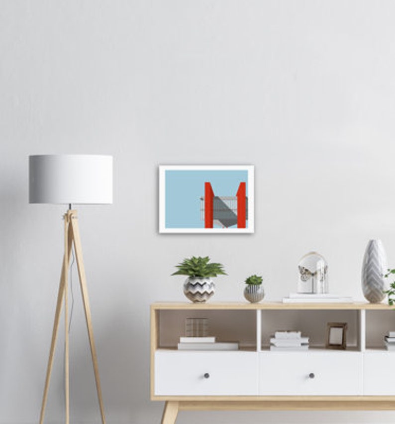 May include: A framed print of a minimalist abstract design featuring a red geometric shape against a light blue background.