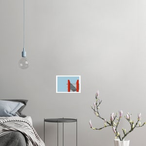 May include: A red and gray geometric structure against a light blue sky.
