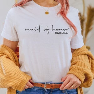 May include: White t-shirt with the text "maid of honor OBVIOUSLY." printed in black.