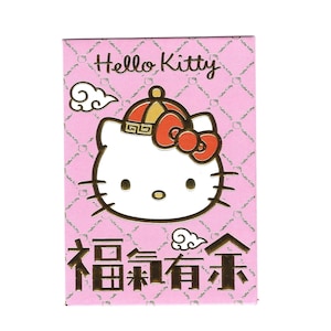 May include: A rectangular pink Hello Kitty card featuring the character's face with a red bow and a traditional hat. The card has Chinese characters and the words "Hello Kitty" in a script font.
