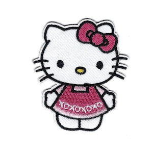 May include: Embroidered patch of a cartoon cat with a white face, black whiskers, and a pink bow. The cat wears a pink dress with the text "xoxoxo" around the hem. The patch has a white border.