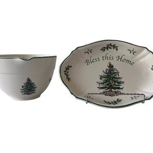 May include: A white ceramic mixing bowl and a white ceramic oval serving dish with a green trim. Both feature a green Christmas tree design and the text "Bless this Home".