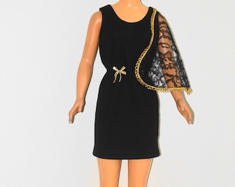 Puede incluir: Una muñeca rubia con un vestido negro sin mangas con ribete dorado y una chal de encaje negro.