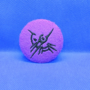 May include: Purple felt patch with a black embroidered design of a stylized scorpion.