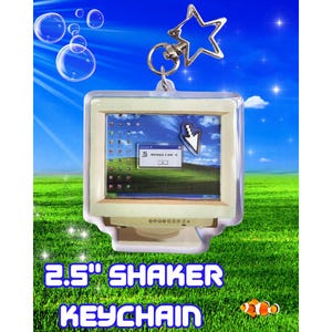 Peut inclure: Un porte-clés shaker de 6,35 cm représentant un écran d'ordinateur miniature avec un curseur et le texte "Nostalgia is over :(". Le porte-clés a un charme en forme d'étoile et un corps en acrylique transparent. Le fond est un ciel bleu et de l'herbe verte.