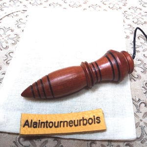 7 cm, 22 g, ø 1,6 cm. Madera de ciruelo. Grabado de Thoth. Péndulo egipcio para radiestesia, fuentes de agua, adivinación y geobiología.