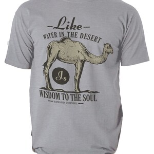 K&ouml;nnte beinhalten: Hellgraues T-Shirt mit Kamel-Illustration und dem Text "Wie Wasser in der W&uuml;ste, Weisheit f&uuml;r die Seele". Das Design enth&auml;lt die Initialen "Js" in einem Kreis und den Namen "Edward Counsel".