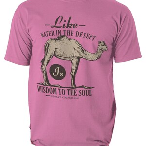 K&ouml;nnte beinhalten: Rosafarbenes T-Shirt mit einer Kamel-Illustration und dem Text "Wie Wasser in der W&uuml;ste, Weisheit f&uuml;r die Seele." Das Design enth&auml;lt die Initialen "Js" in einem Kreis und den Namen "Edward Counsel".