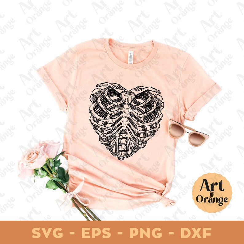 May include: A pink t-shirt with a black and white illustration of a ribcage in the shape of a heart. The text "Art of Orange" is in a circle on the bottom right corner of the image.