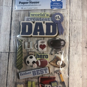 May include: A pack of 12 3D stickers with a Father's Day theme. The stickers include a blue ribbon with the text "#1" and the words "world's greatest DAD". Other stickers include a tie, a mug, a grill, a football, a baseball, a toolbox, a hammer, and a heart.