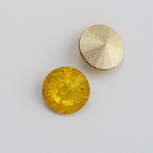 May include: Two round buttons, one gold and one yellow. The gold button has a textured surface. The yellow button has a sparkly, glittery surface.