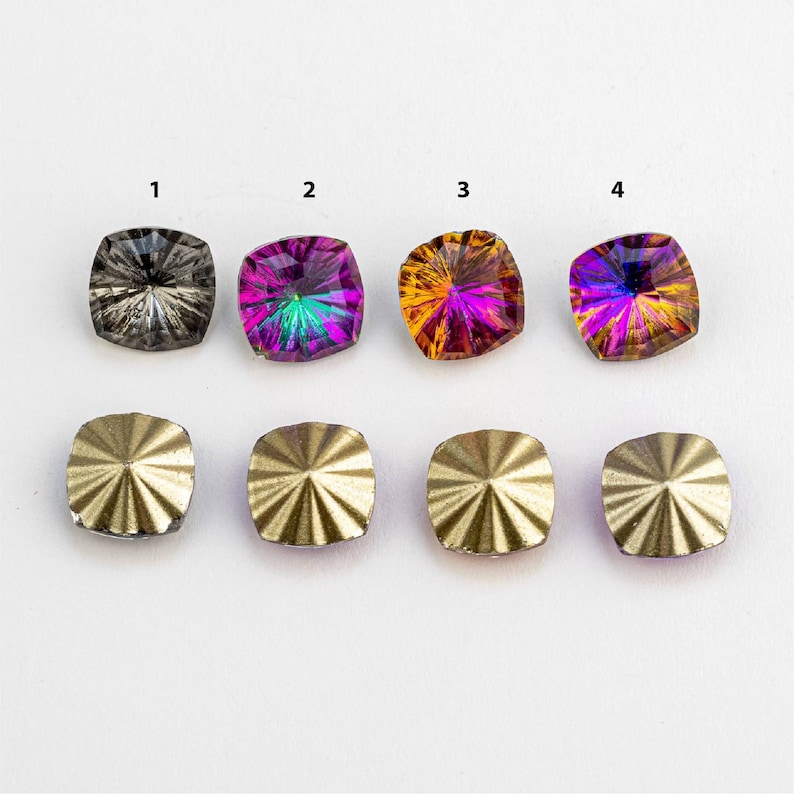 May include: Four square-shaped iridescent gemstones with a rainbow effect. The gemstones are arranged in a row, with the numbers 1 through 4 printed above each one. Below the gemstones are four gold-colored metal settings with a starburst design.