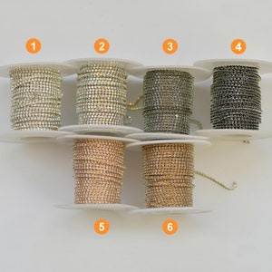 Puede incluir: Seis carretes de galón de cadena de strass en varios colores, incluyendo transparente, iridiscente, negro, dorado y oro rosa. Los carretes están etiquetados con los números del 1 al 6.