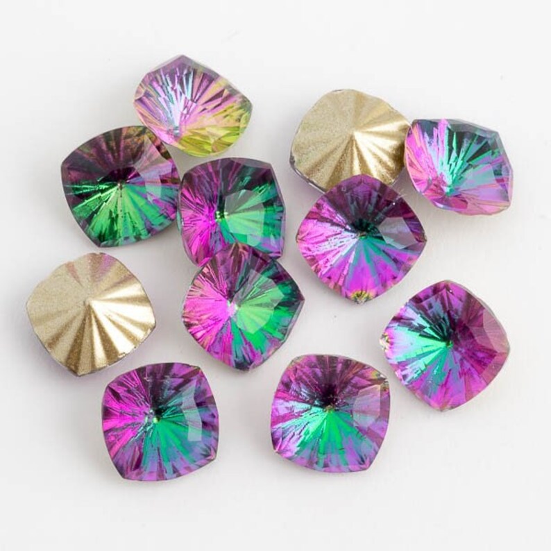 May include: Assortment of iridescent square-shaped glass rhinestones in shades of green, pink, and gold. The rhinestones have a faceted design and a pointed back.