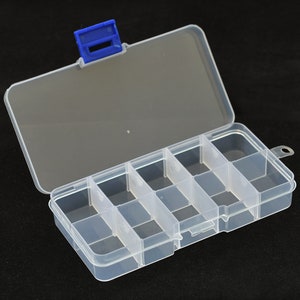 以下が含まれることがあります： 青いラッチが付いた透明なプラスチック製の収納ボックス。ボックスには8つのコンパートメントがあり、小さなアイテムの整理に最適です。