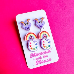 May include: Purple dragon earrings with rainbow and paint palette charms. The earrings are on a white card with the text "Mommin' with the Mouse".
