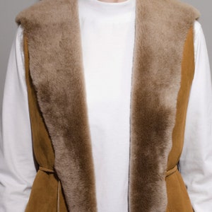 May include: A brown suede vest with a faux fur collar and a tie closure. The vest is lined with a soft, brown faux fur.