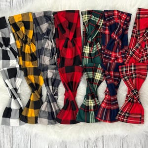 May include: A set of eight plaid headbands in various colours, including red, black, white, yellow, and green. The headbands are made of a soft, stretchy fabric and are perfect for adding a touch of style to any outfit.