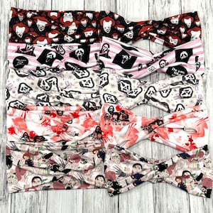 May include: A collection of twisted headbands featuring horror movie characters and imagery. Designs include Pennywise, Ghostface, and Chucky, with patterns in red, pink, black, and white. Some headbands have text like "Do you like scary movies?"