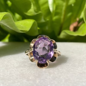 Peut inclure: Une bague en or avec une améthyste violette sertie dans un motif floral.