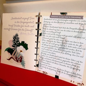 May include: A pink and green journal with a quote about gratitude. The quote reads, "Gratitude creates sense in the past, brings peace for today, and creates visions for the future." - Melody Beattie.