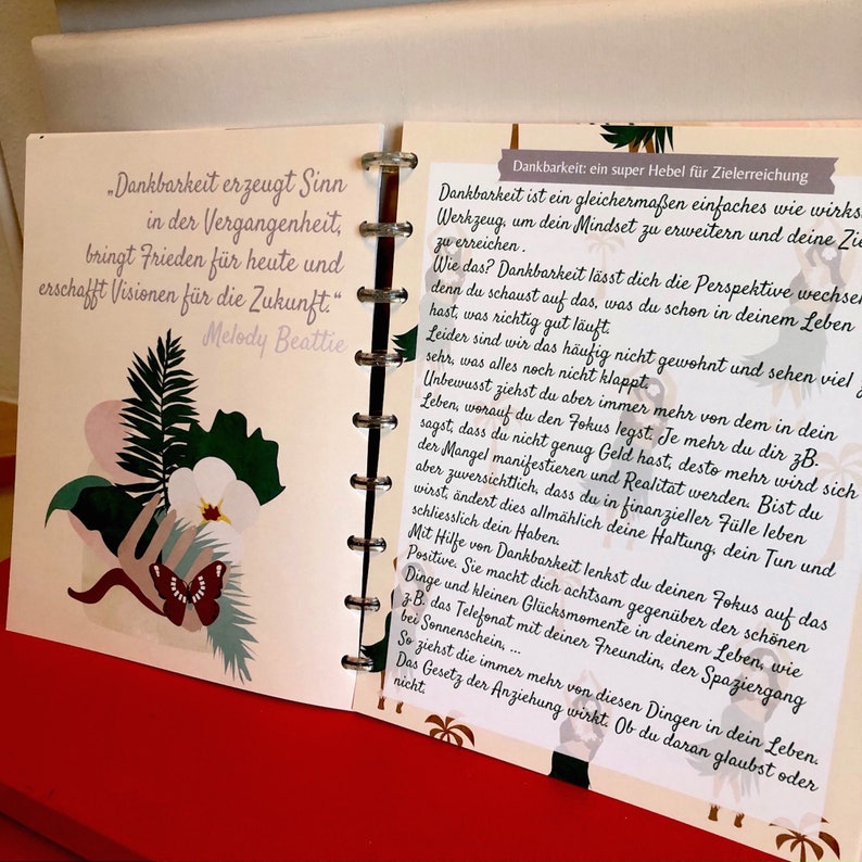 May include: A pink and green journal with a quote about gratitude. The quote reads, "Gratitude creates sense in the past, brings peace for today, and creates visions for the future." - Melody Beattie.