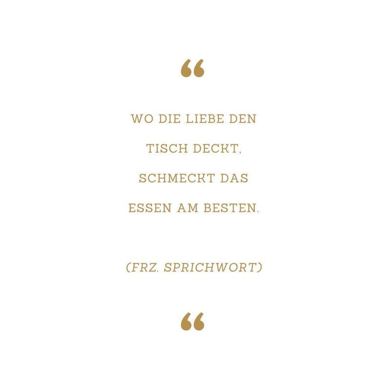 May include: A quote in gold text on a white background. The quote reads: "Wo die Liebe den Tisch deckt, schmeckt das Essen am besten. (FRZ. SPRICHWORT)"