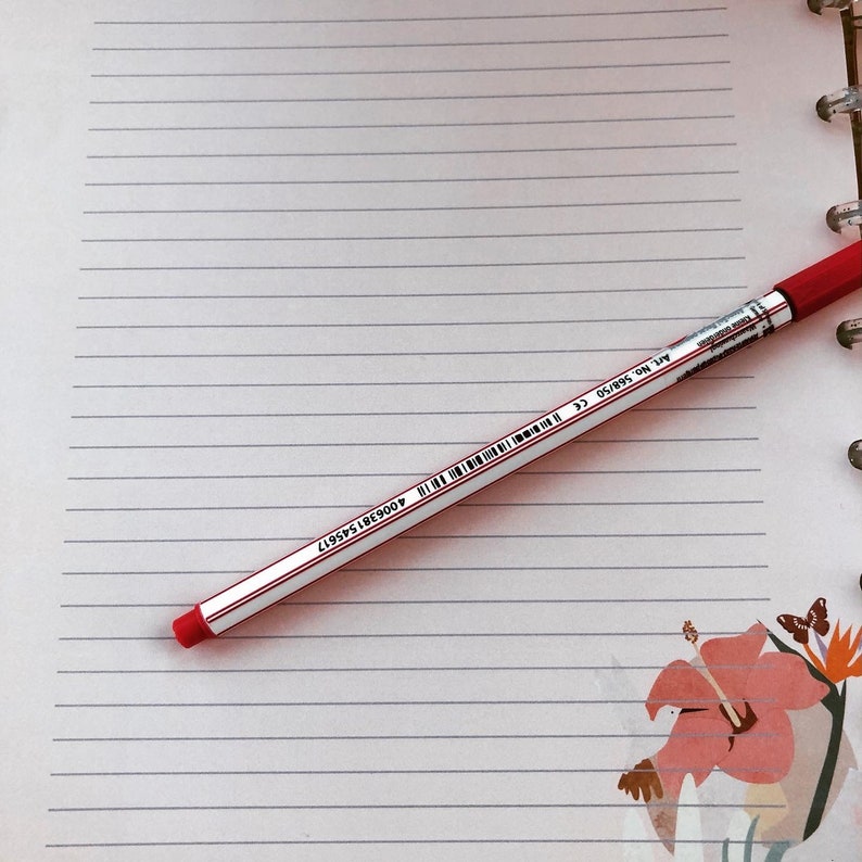 May include: A red pen with white markings on a lined notebook page. The pen has the text "Art. No. 50895-50" and "400981545917" printed on it.